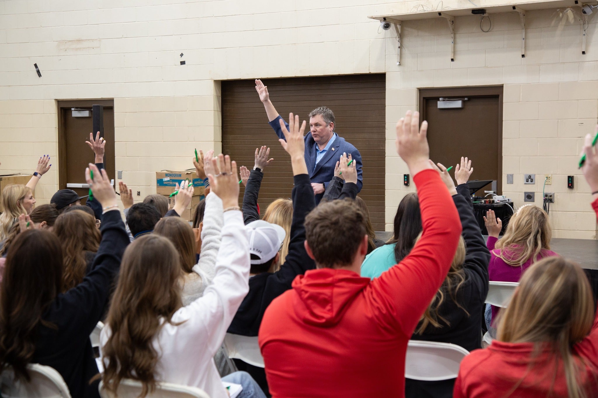 Students raising their hands to answer a presenter at OYE Leadership Summit 2024.