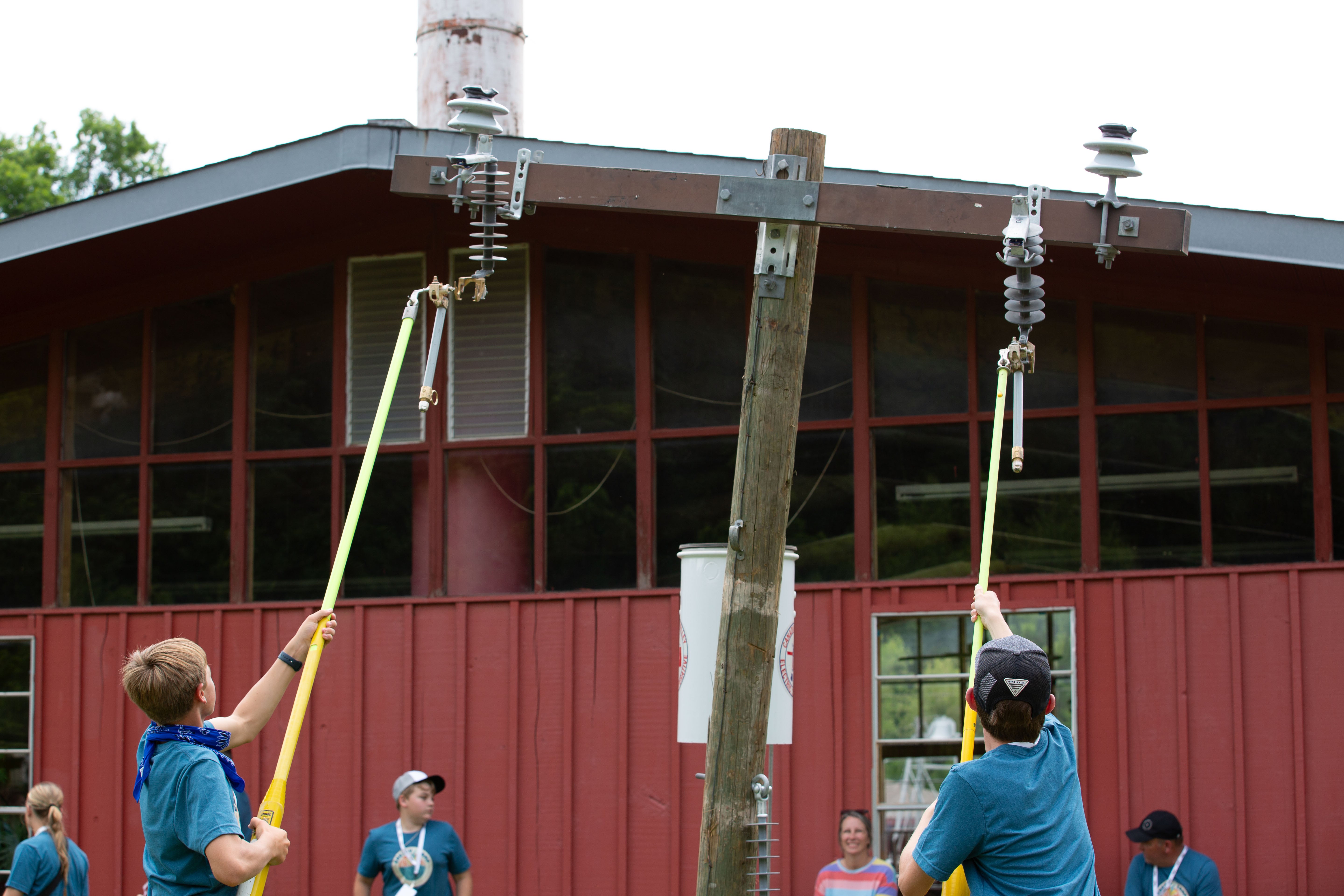 Energy Camp participants using hotsticks to change fuses.