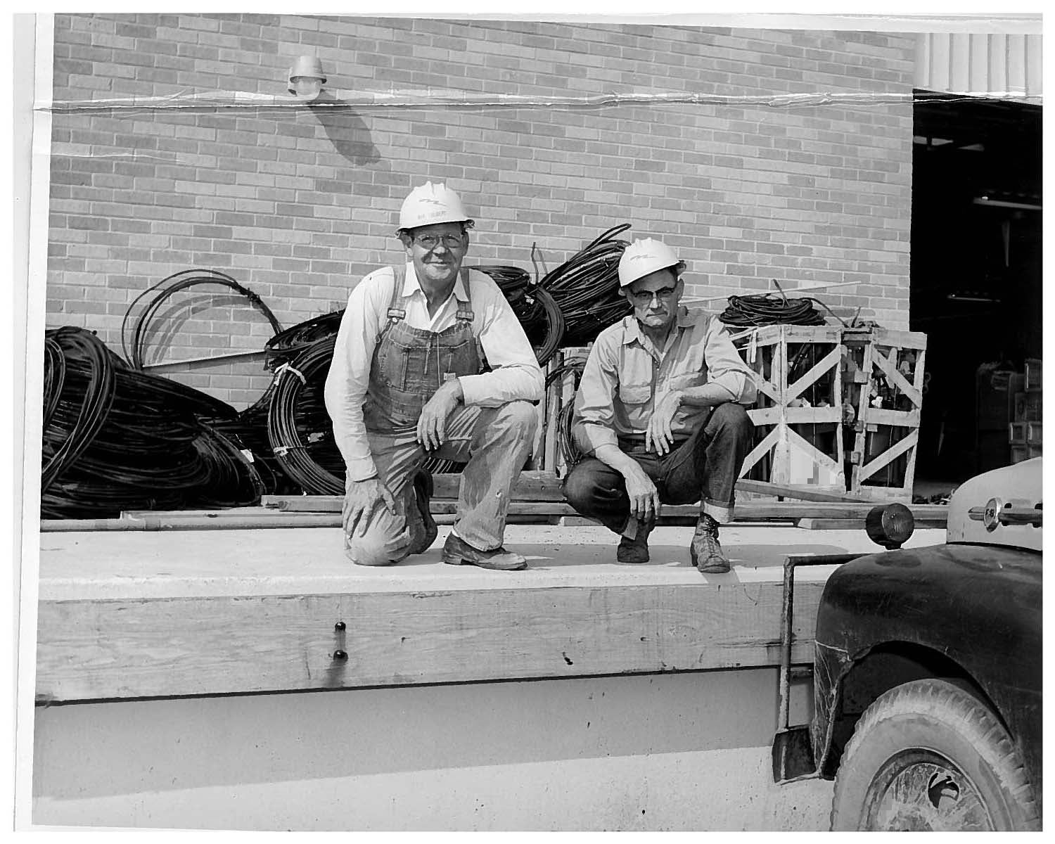 Two former employees kneeling on a docking bay ledge.