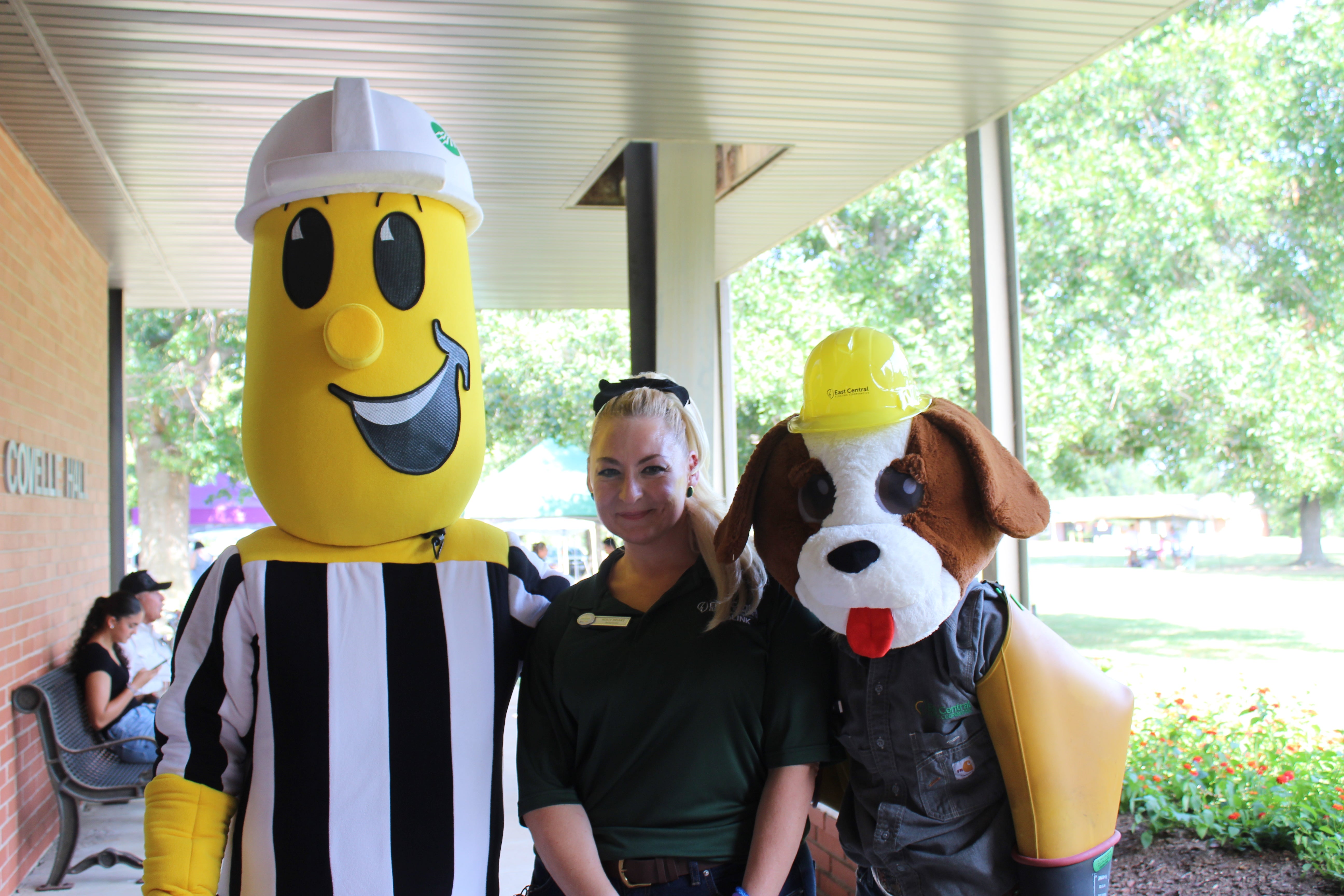 Photo of Willie Wiredhand and Pluggy the Pug at the 2023 Annual Meeting with ECE Employee Holly Brians.