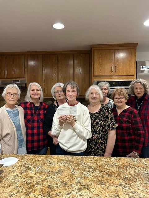 Volunteers at Senior Moments hold a check that will be used to purchase food.