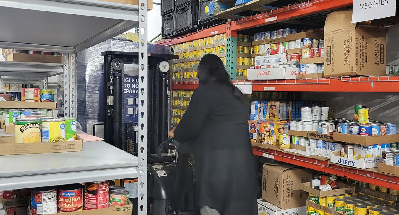 Bristow Social Services Executive Director Toni Godwin operates pallet jack in warehouse.