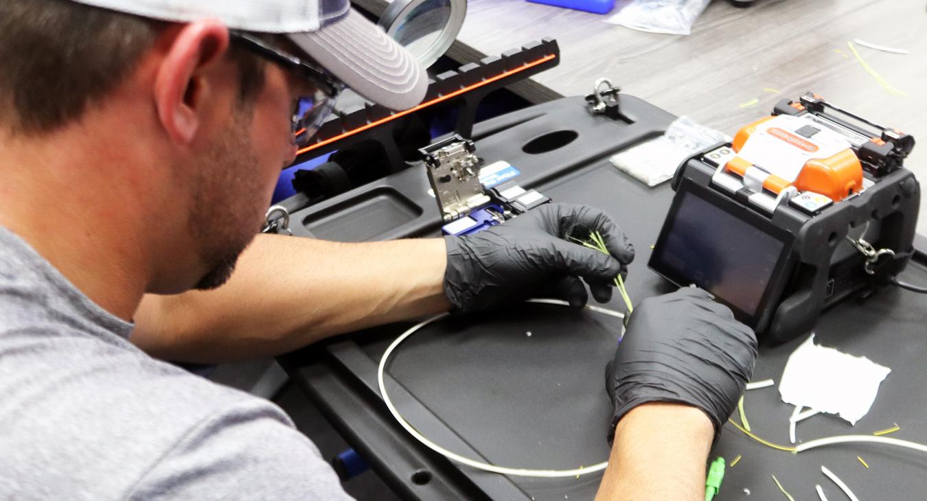 One of our ecoLINK fiber technicians inspects and prepares the glass fibers that make up our internet infrastructure to be spliced together.